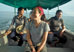 Three female team members from ProCosta ride in a boat.